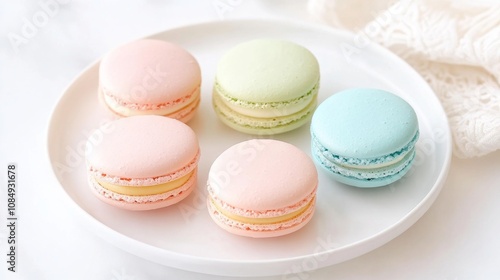 A colorful assortment of macarons displayed on a white plate, showcasing pastel shades and a delightful confectionery appeal.