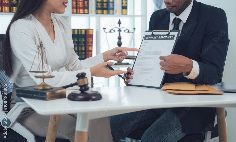 Legal Consultation: A lawyer and client review documents together, showcasing trust and collaboration in a professional legal setting. Legal Consultation: A lawyer and client review documents together, showcasing trust and collaboration in a professional legal setting.