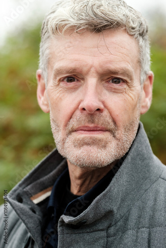 Portrait of confident senior man with grey hair and beard showing experience and wisdom