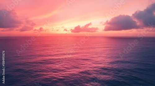 A sunrise over the ocean, with the sky transitioning from pink to orange.