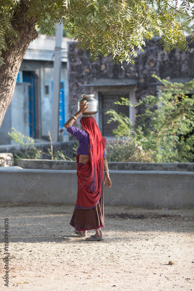 rural Indian Woman carry water on their heads in traditional pots from well, everyday Women walk few kilometers to get water due to drought rural Indian Woman carry water on their heads in traditional pots from well, everyday Women walk few kilometers to get water due to drought