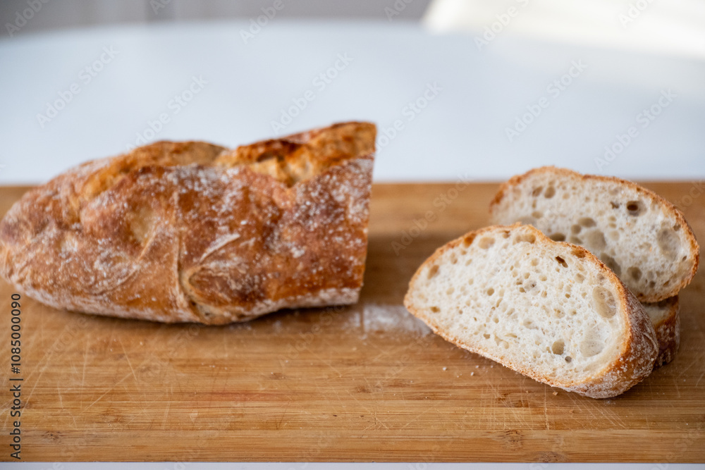 Freshly baked loaf of bread on a wooden cutting board Freshly baked loaf of bread on a wooden cutting board