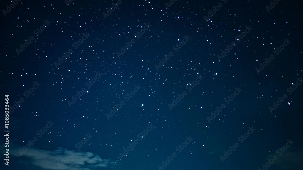 Fototapeta premium Starry night sky filled with twinkling stars over a calm landscape at dusk