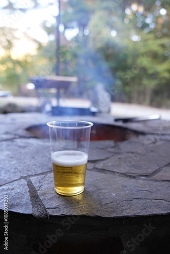 Fire pit with a cup of beer in the foreground