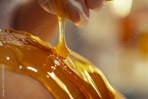 Close-up of a woman's arms preparing for sugaring in a cosmetology salon. Honey bottle near the leg, highlighting a gentle and tender care routine. photo