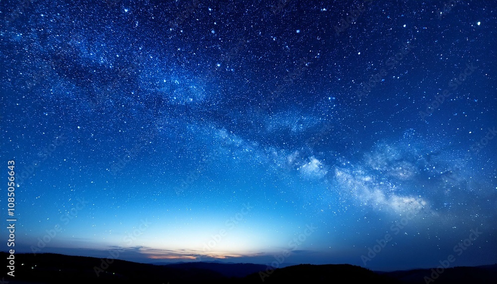 Fototapeta premium 深い青色の夜空に、星々が静かに輝く穏やかな夜の空が広がる背景。