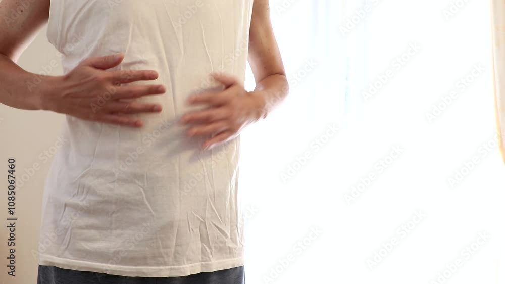 両手でお腹を叩く男性 両手でお腹を叩く男性