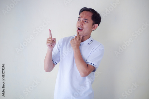 Man Expressing Displeasure with Stern Look and Pointing Gesture in Casual White Shirt
