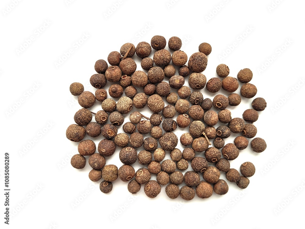 Raw portion of allspice seeds on a white background. Raw portion of allspice seeds on a white background.