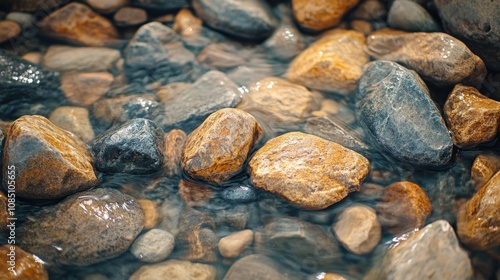 Macro drone shot of small rocks in a stream. See the natural pattern of the rock surface from water erosion and reflection of the flowing water.