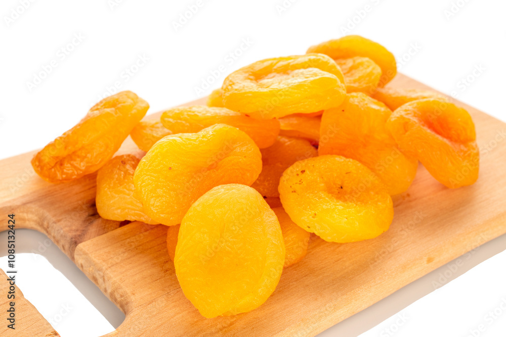 Sweet dried apricots on a wooden kitchen board, close-up, isolated on a white background. Sweet dried apricots on a wooden kitchen board, close-up, isolated on a white background.