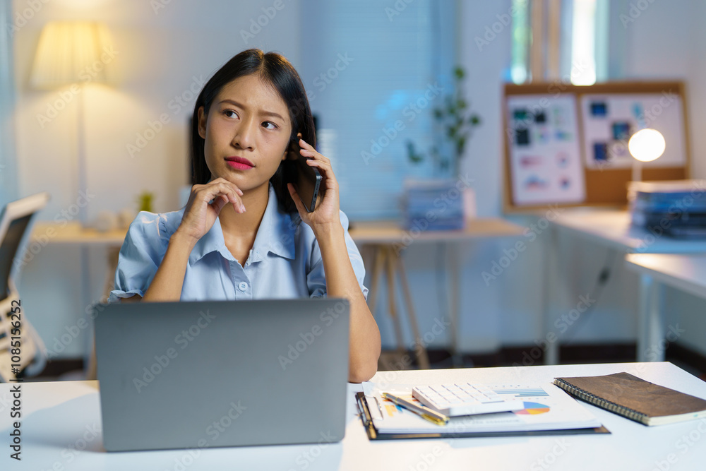 Female office workers talk via smartphone and communicate online with customers, business partners, and various business people who invest in the business. Woman sitting at table in modern office. Female office workers talk via smartphone and communicate online with customers, business partners, and various business people who invest in the business. Woman sitting at table in modern office.