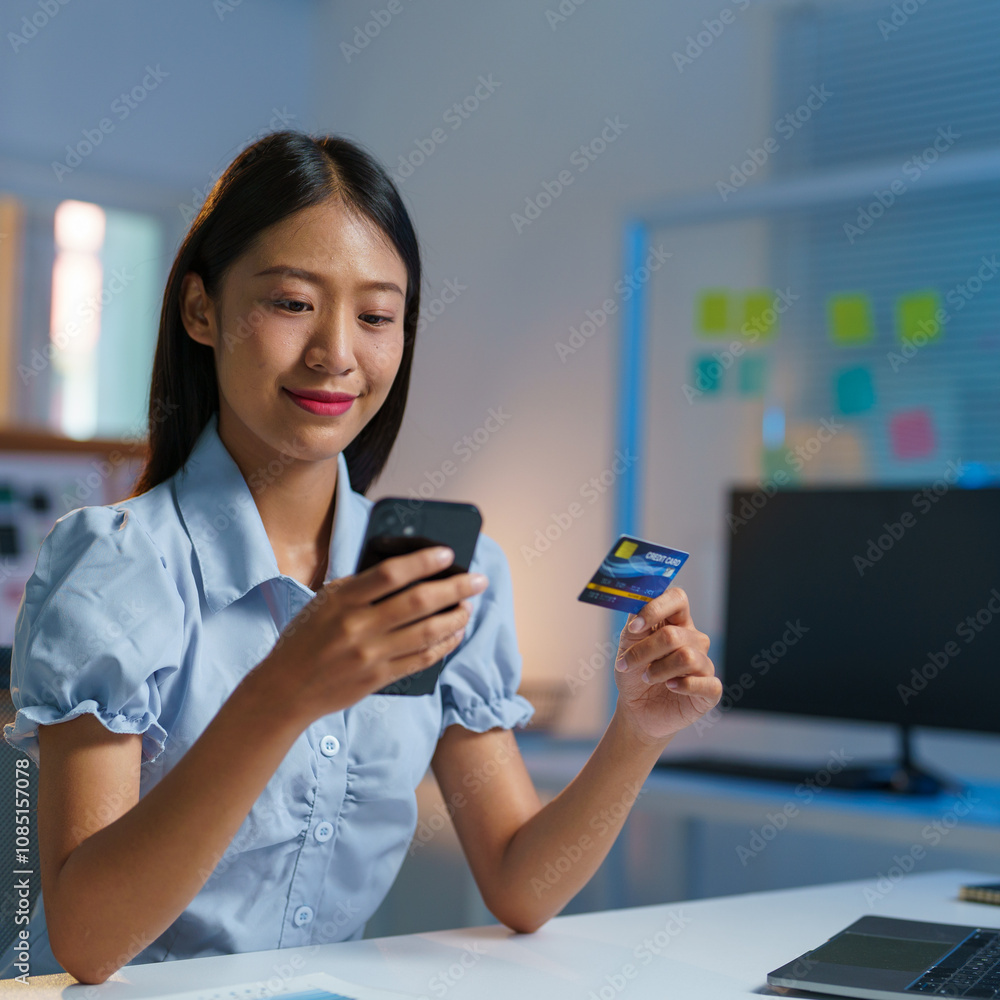 Confident Asian businesswomen sitting at their desks Are using banking applications to buy or pay online mobile bills. and registered her credit card on the website for online purchases. Confident Asian businesswomen sitting at their desks Are using banking applications to buy or pay online mobile bills. and registered her credit card on the website for online purchases.