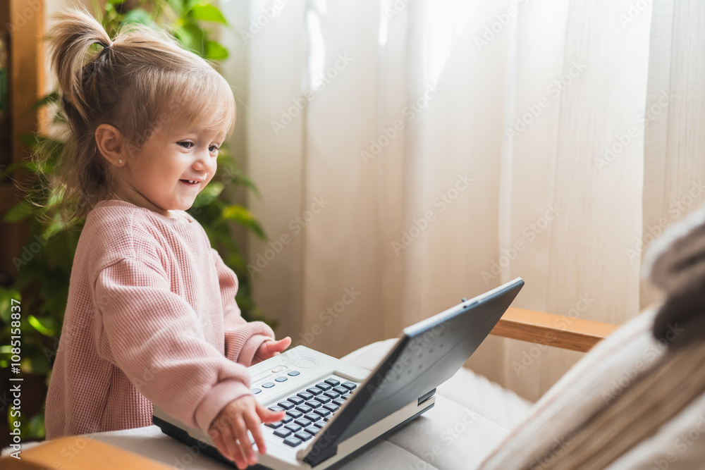 Young Girl Smiling While Engaging With Toy Laptop, Highlighting Early Education And Playful Interaction Young Girl Smiling While Engaging With Toy Laptop, Highlighting Early Education And Playful Interaction