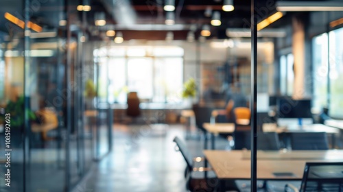 Blurry view of a modern office interior highlighting collaborative workspaces and natural light