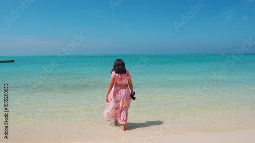 Pretty Indian woman walking towards beach at dreamy island. Tourist at Agatti Island in Lakshadweep, India. Girl enjoying holiday at tropical white sand beach. photo