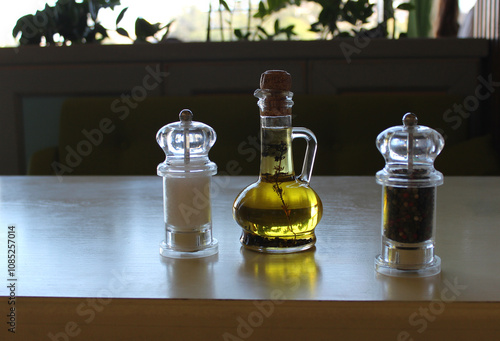 Принти на полотні Glass Bottle With Oil And Herbs, Salt Cellar And Pepper Shaker On A Clean Restau