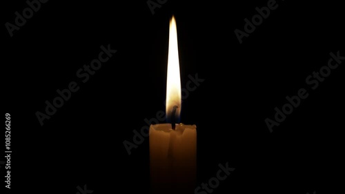 Single candle burning in the dark, providing a warm glow. The flame flickers gently, creating a peaceful and contemplative atmosphere