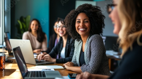 Empowered Women in Tech: A diverse group of smiling women collaborate on laptops in a modern office, showcasing female empowerment and teamwork in the tech industry. 