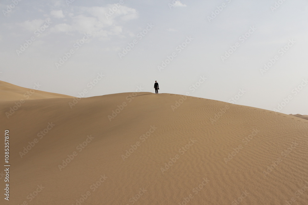 The smooth ridges of desert sand dunes stretch under a vast, cloud-dappled sky, showcasing nature�s beauty. The smooth ridges of desert sand dunes stretch under a vast, cloud-dappled sky, showcasing nature�s beauty.