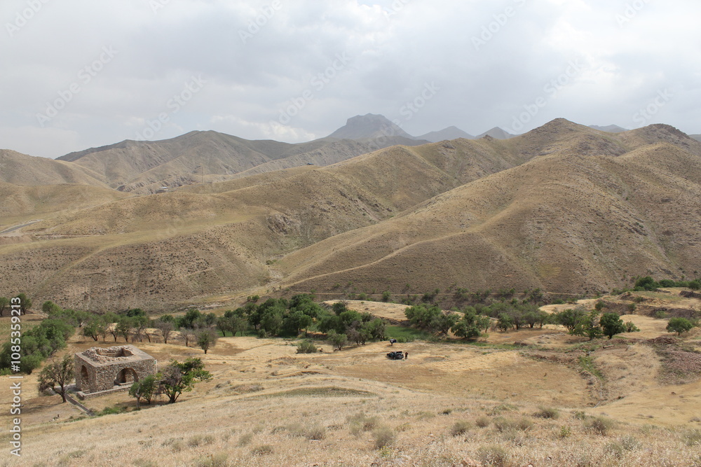 A vast mountainous landscape under soft clouds, representing natural rugged beauty. A vast mountainous landscape under soft clouds, representing natural rugged beauty.