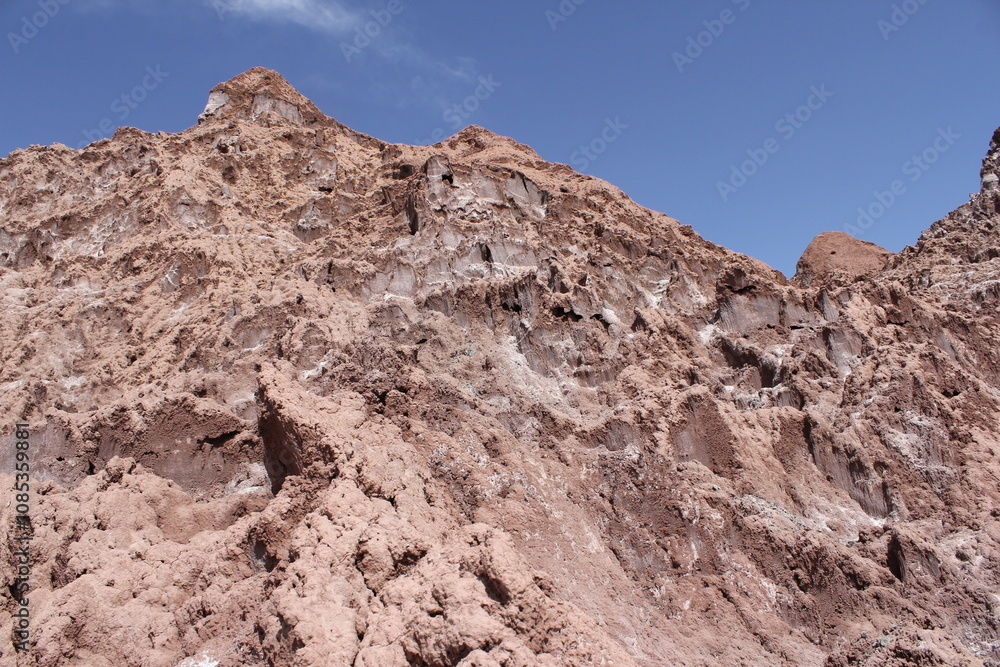 Distant mountains under a blue sky in a desert, with rough terrain and rugged rocks dominating the scene. Distant mountains under a blue sky in a desert, with rough terrain and rugged rocks dominating the scene.