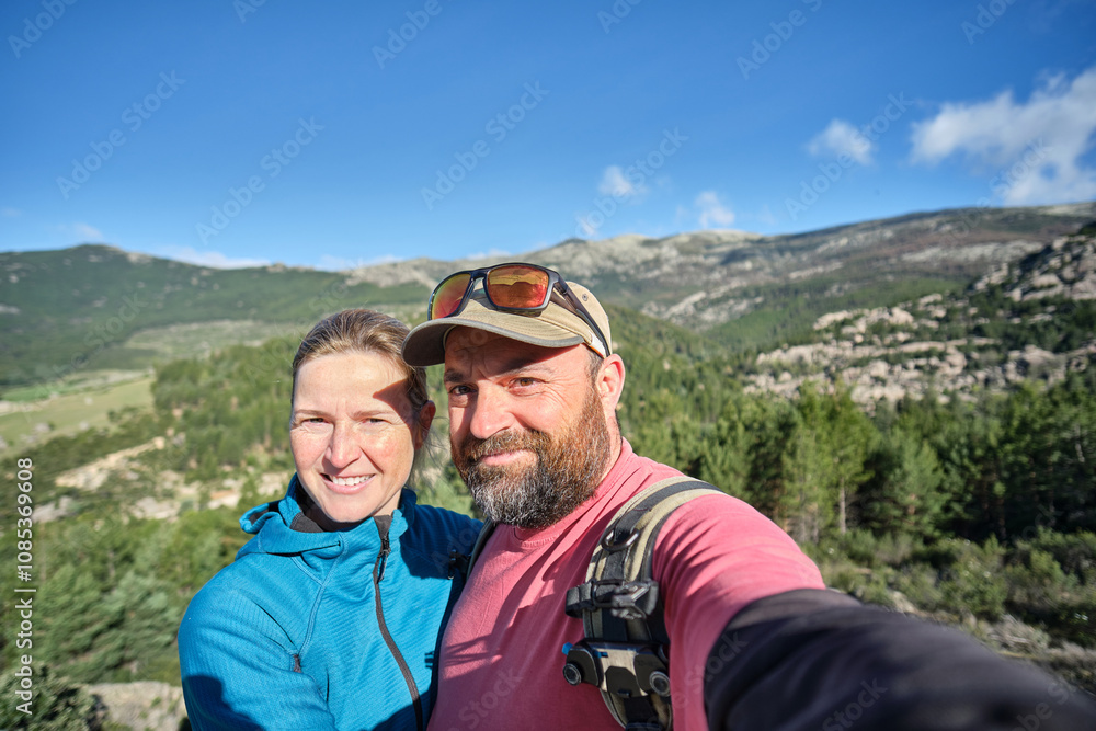 A Couple taking a selfie while hiking in the mountains A Couple taking a selfie while hiking in the mountains