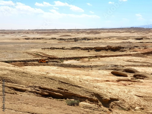 An expansive desert view showcasing flat sandy plains under a bright, cloudless blue sky�perfect for minimalistic travel and nature concepts.