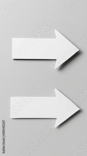 Right Direction: Two minimalist white arrows pointing right against a neutral grey background. A simple yet powerful visual for guidance and direction. 