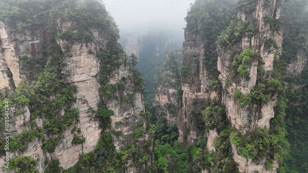 Fototapeta premium Aerial drone shot capturing Zhangjiajie’s mystical peaks and cloudy landscape in China, famously inspiring the Avatar movie’s floating mountains