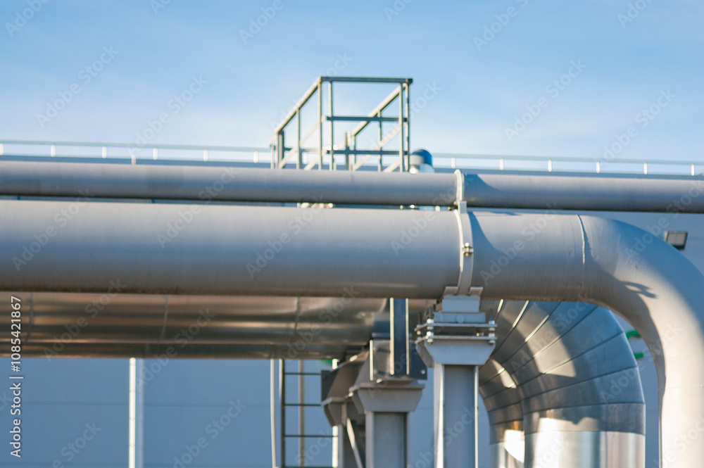 The photo shows a pipeline against the background of a gray building wall The photo shows a pipeline against the background of a gray building wall