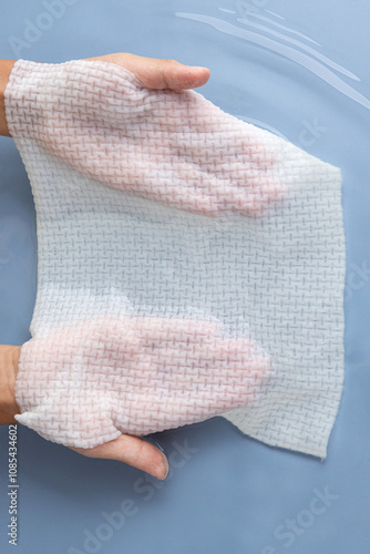 showing the absorbent disposable face towel with both hands.