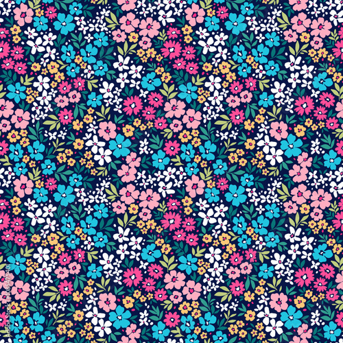 Cute floral background. Floral pattern with small colorful flowers on a dark blue background. Seamless pattern for design and fashion prints. Ditsy style. Stock vector illustration.