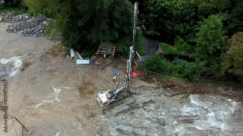 a drilling machine at a construction site as it drills holes for pouring concrete piles. This top view captures the process of foundation preparation. Perfect for construction and engineering themes.