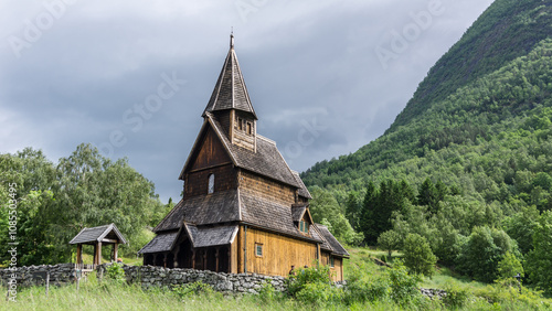 historische Stabkirche Urnes in Norwegen, das Holzgebäude ist umgeben von grünen Wiesen und Wald photo