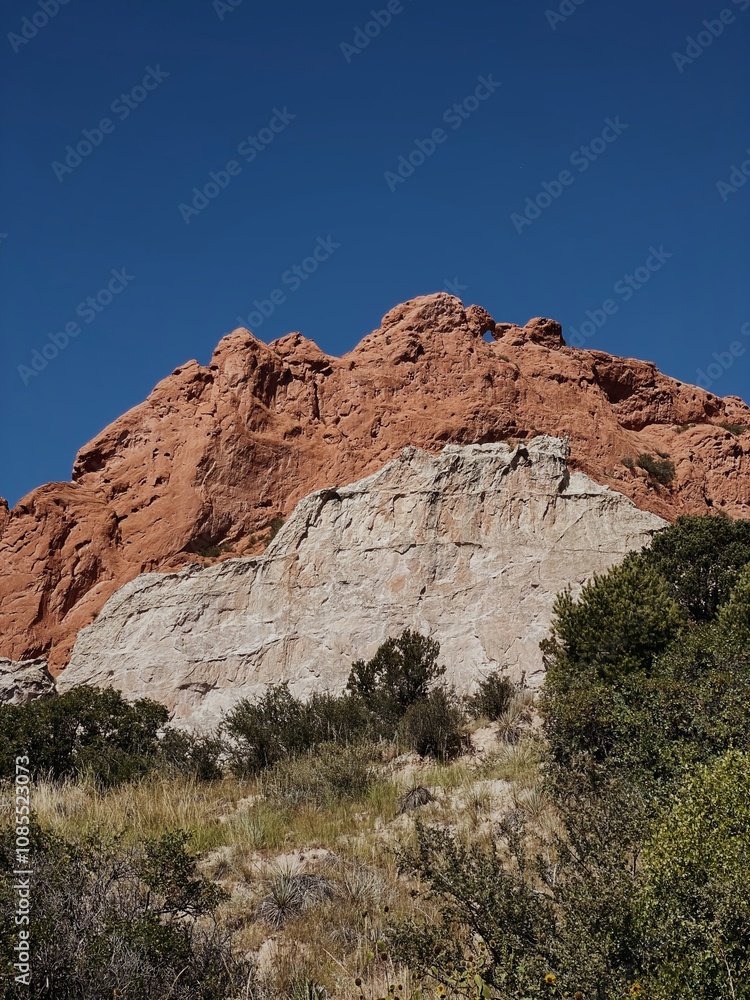 The iconic red sandstone formations of Garden of the Gods, Colorado, set against a vivid blue sky, offering a glimpse into the unique beauty of this celebrated natural landmark The iconic red sandstone formations of Garden of the Gods, Colorado, set against a vivid blue sky, offering a glimpse into the unique beauty of this celebrated natural landmark