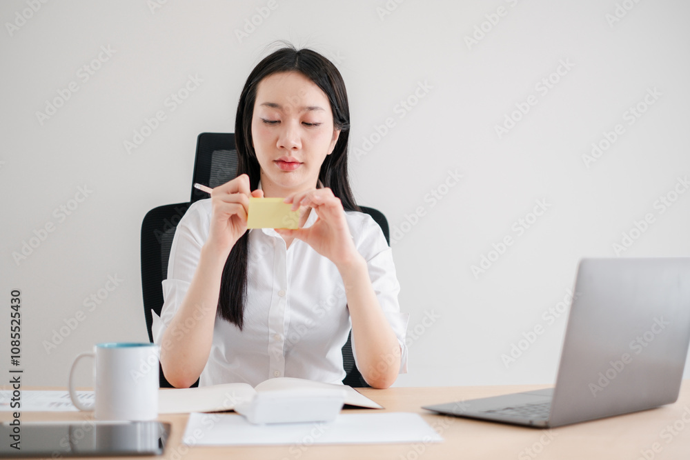 Focused Businesswoman Writing Notes at Desk in Modern Office Environment with Minimalist Design