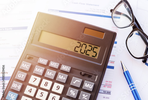 A calculator displays the year 2025 alongside financial documents