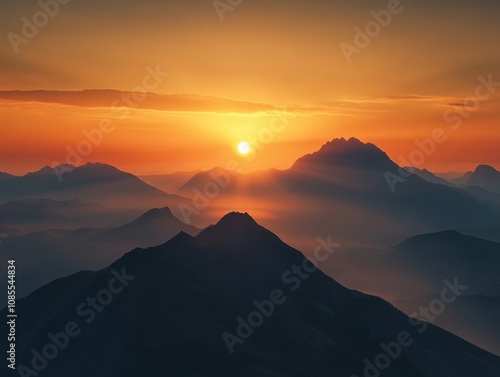 Majestic sunset casting a warm, orange glow over a dramatic mountain range. The silhouettes of the peaks are breathtaking against the fiery sky.