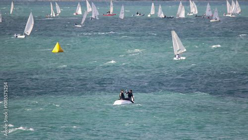 Obraz na płótnie Yachtsmen sit on the hull of a capsized yacht and wait for help at sea in strong winds w salonie