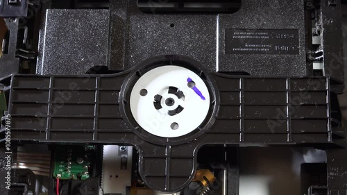 An open DVD player shows its internal components and circuitry, with the disc loading and unloading movements, seen from several angles. This image highlights the technology and design of home enterta photo