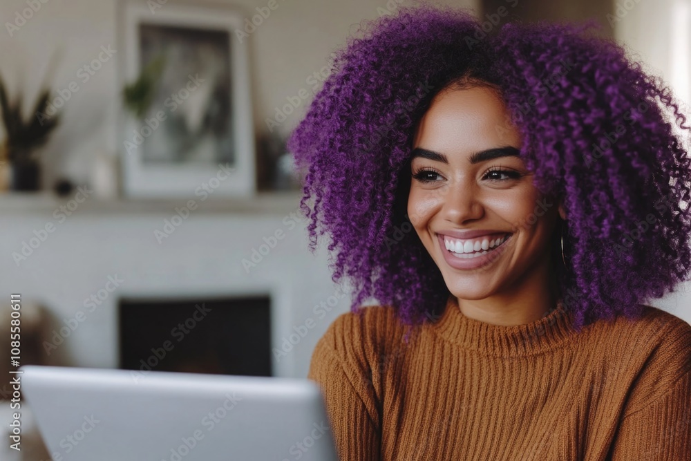 Happy young mixed-race woman with purple hair using a laptop at home. Happy young mixed-race woman with purple hair using a laptop at home.