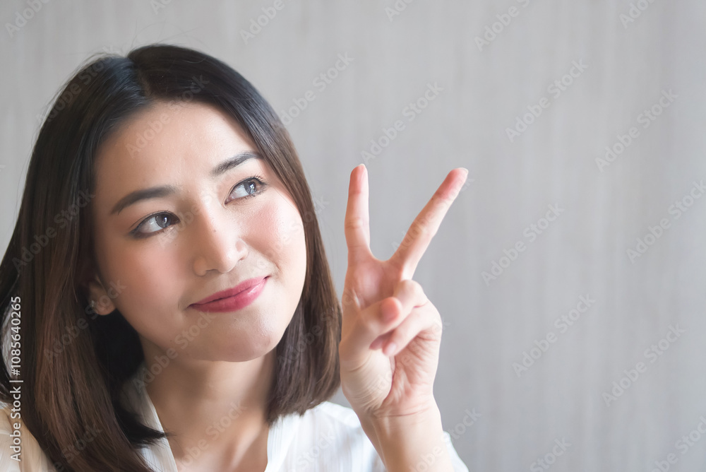Happy smiling asian woman pointing up two fingers, v for victory Happy smiling asian woman pointing up two fingers, v for victory