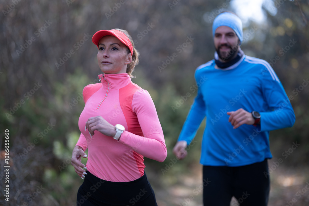 trail running with a sporty couple in the magic forest in early morning trail running with a sporty couple in the magic forest in early morning