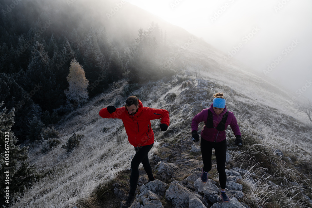 trail running couple man and woman running on a mountain path trail running couple man and woman running on a mountain path