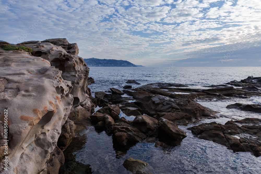 Fototapeta premium Stone shore of sea against the sky in overcast morning