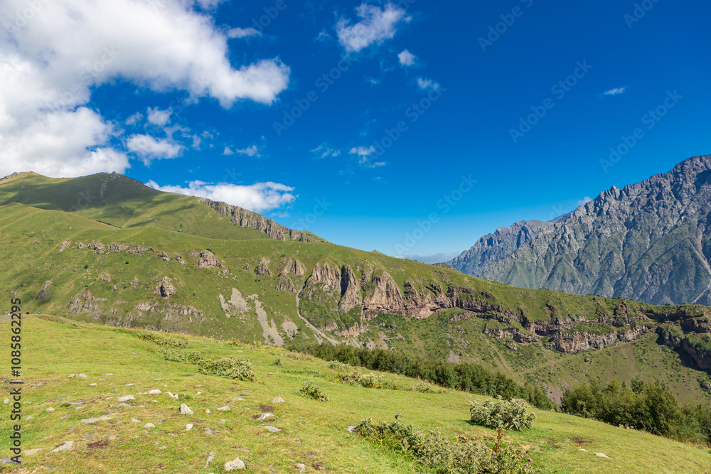Fototapeta premium Caucasian mountains near Gergeti village, Stepansminda. Kazbegi mountain behind the clouds. Georgia