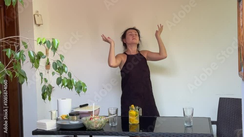 Woman cutting orange for lemonade, preparing healthy salad and serving table 