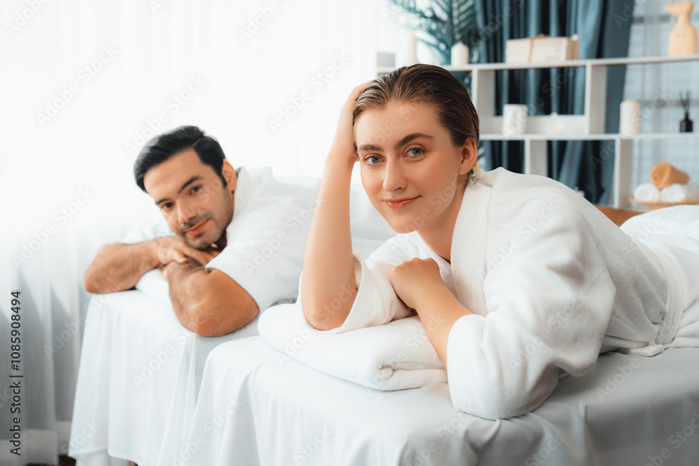 Fototapeta premium Caucasian couple customer enjoying relaxing anti-stress spa massage and pampering with beauty skin recreation leisure in day light ambient salon spa at luxury resort or hotel. Quiescent