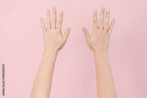 Manicured nails, beautiful woman hands forming an elegant shape on pink background